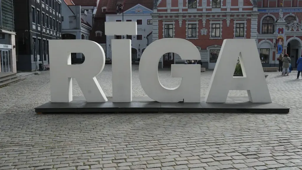Liels uzraksts RĪGA uz bruģētas ielas vēsturiskā pilsētas centrā Rīgā.