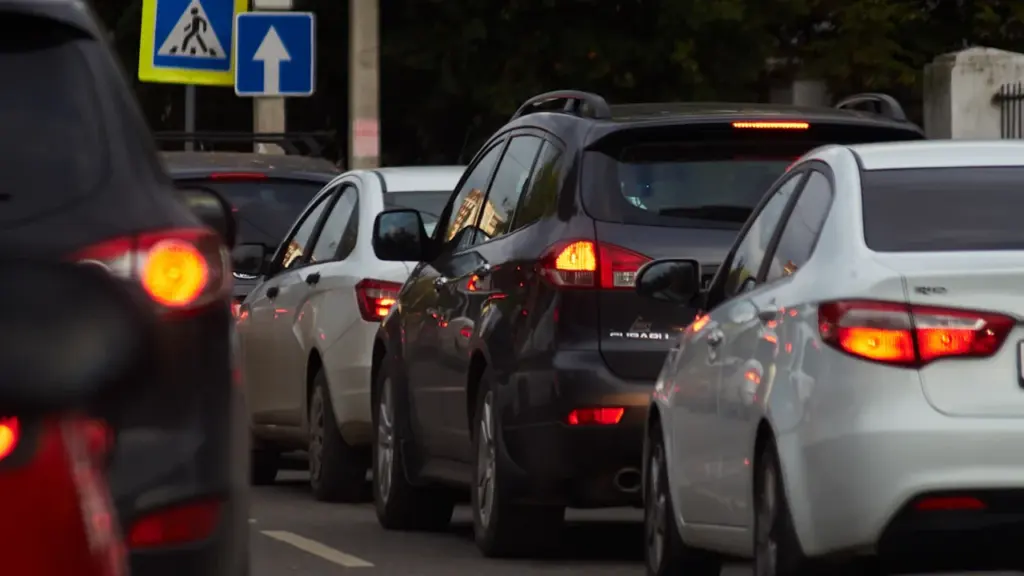 Automašīnas stāv sastrēgumā Rīgas ielās, pie gājēju pārejas ceļa zīmēm.