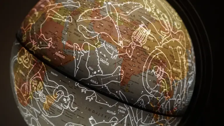 Sīki detalizēts zvaigžņu globuss ar attēlotajiem zvaigznājiem tumšā un noslēpumainā astroloģiskā gaisotnē.