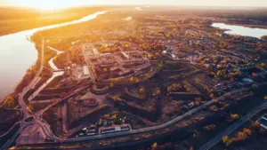 Putnisks skats uz Daugavpili un Daugavas upi zelta stundā vasaras vakarā.