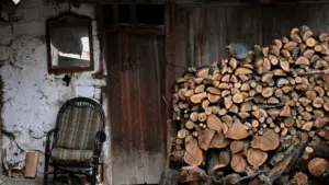 Malkas krāvums un krēsls lauku mājā, gatavojoties vēsajai apkures sezonai Latvijā.