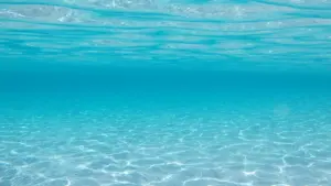 Saules stari atspīd dzidrā tirkīzzilā ūdenī, radot mierīgu un meditatīvu atmosfēru.