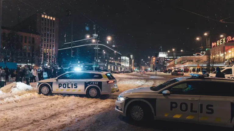 Valsts policijas automašīnas uz piesnigušas ielas reida laikā vakarā pilsētā.