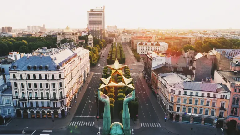 Brīvības piemineklis Rīgā saulrietā, simbolizējot Latvijas neatkarību un valstisko identitāti pilsētas centrā.